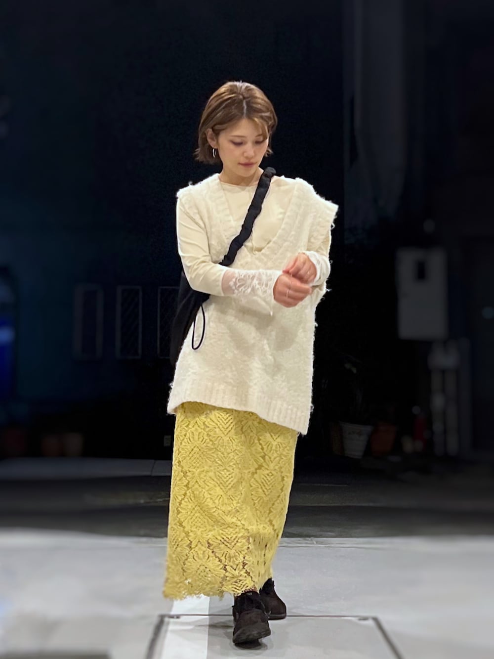 ブラック系のショルダーバッグ、ベージュ系のTシャツ/カットソー、ホワイト系のニット/セーターを着用したレディースの冬コーディネートの2枚目の写真