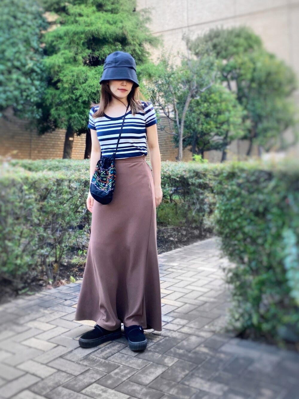 ブルー系のニット/セーター、ブラウン系のスカート、ブラック系のショルダーバッグを着用したレディースの夏コーディネートの3枚目の写真