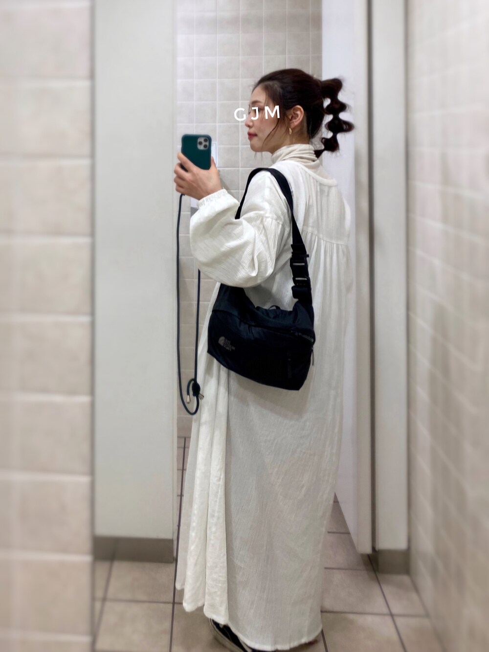 ホワイト系のワンピース、ホワイト系のトップス、ブラック系のスニーカーを着用したレディースの冬コーディネートの3枚目の写真