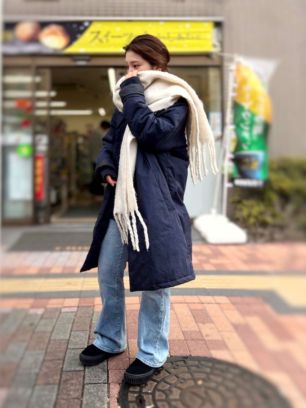 ブルー系のデニムパンツ、ブラック系のスリッポン、ブラック系のボディバッグ/ウエストポーチを着用したレディースの冬コーディネートの3枚目の写真