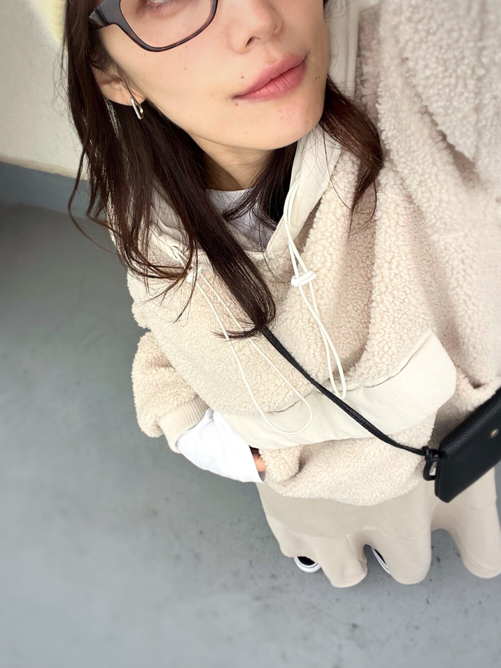 ブラック系のスニーカー、ベージュ系のワンピース、ベージュ系のパーカーを着用したレディースの冬コーディネートの3枚目の写真