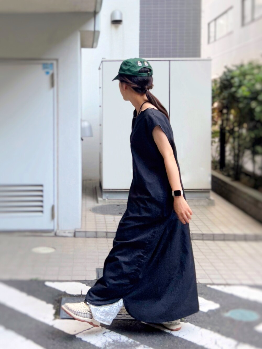 ホワイト系のサンダル、ブラック系のワンピース、ブラック系のショルダーバッグを着用したレディースの夏コーディネートの2枚目の写真