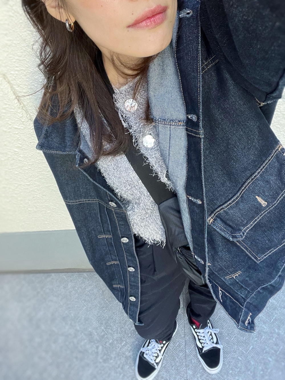 ブラック系のスニーカー、ブラック系のパンツ、ブルー系のデニムジャケットを着用したレディースの冬コーディネートの4枚目の写真