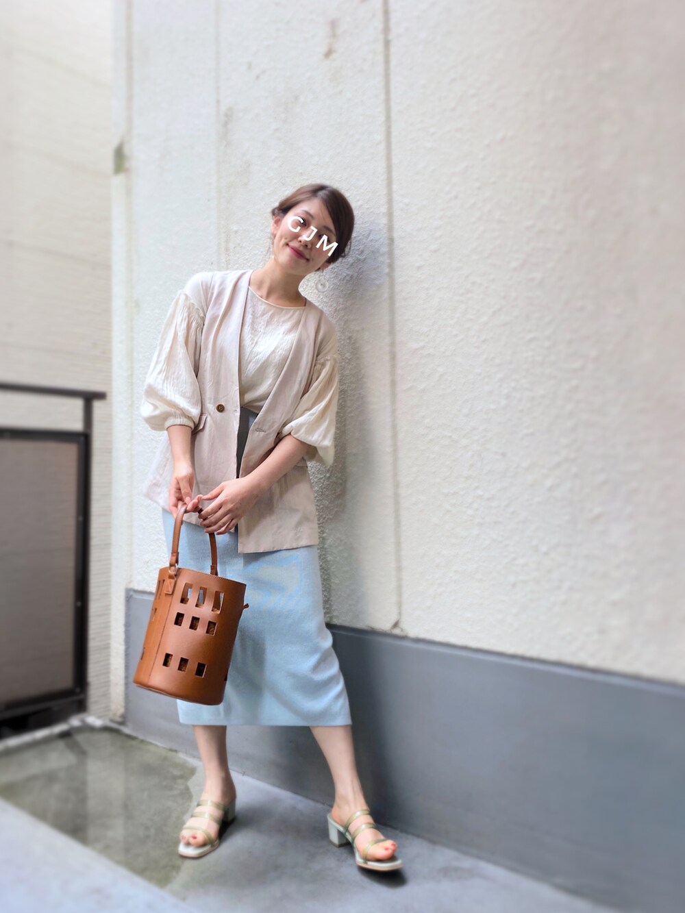 ブルー系のスカート、グリーン系のサンダル、ブラウン系のバッグを着用したレディースの春コーディネートの2枚目の写真