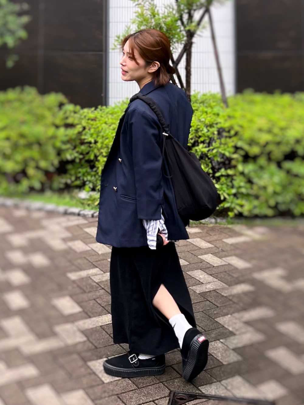 ブラック系のショルダーバッグ、ブルー系のテーラードジャケット、ブラック系のワンピースを着用したレディースの冬コーディネートの2枚目の写真