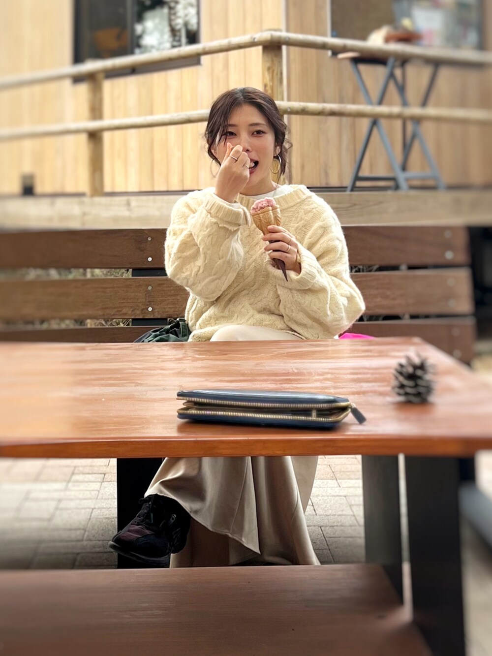 ベージュ系のワンピース、ホワイト系のニット/セーター、ブラウン系のスニーカーを着用したレディースの春コーディネートの2枚目の写真