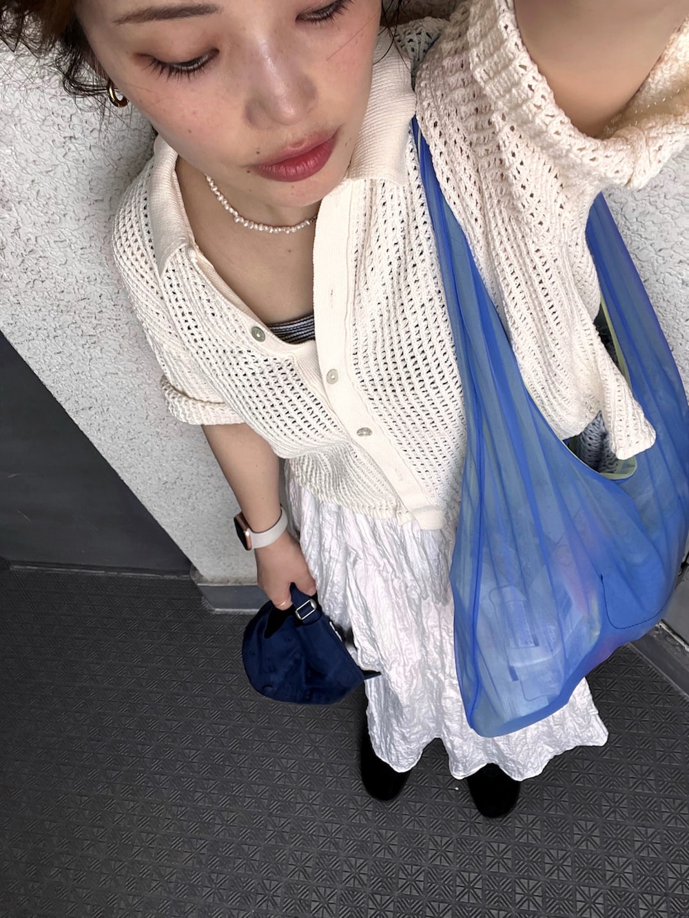 ホワイト系のカーディガン/ボレロ、ホワイト系のスカート、ブラウン系のスニーカーを着用したレディースの夏コーディネートの4枚目の写真