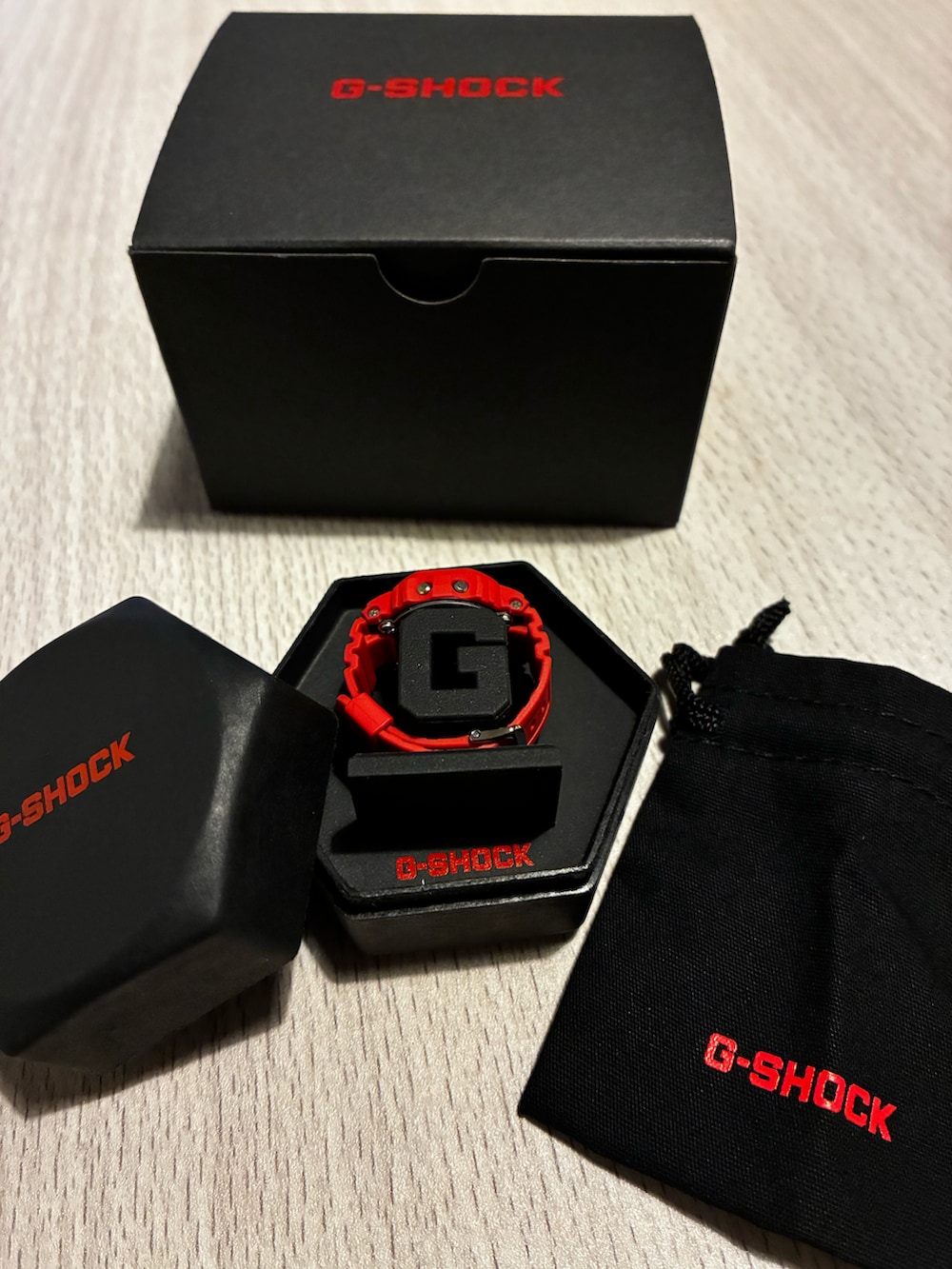 レッド系のデジタル腕時計を着用したレディースの春コーディネートの2枚目の写真