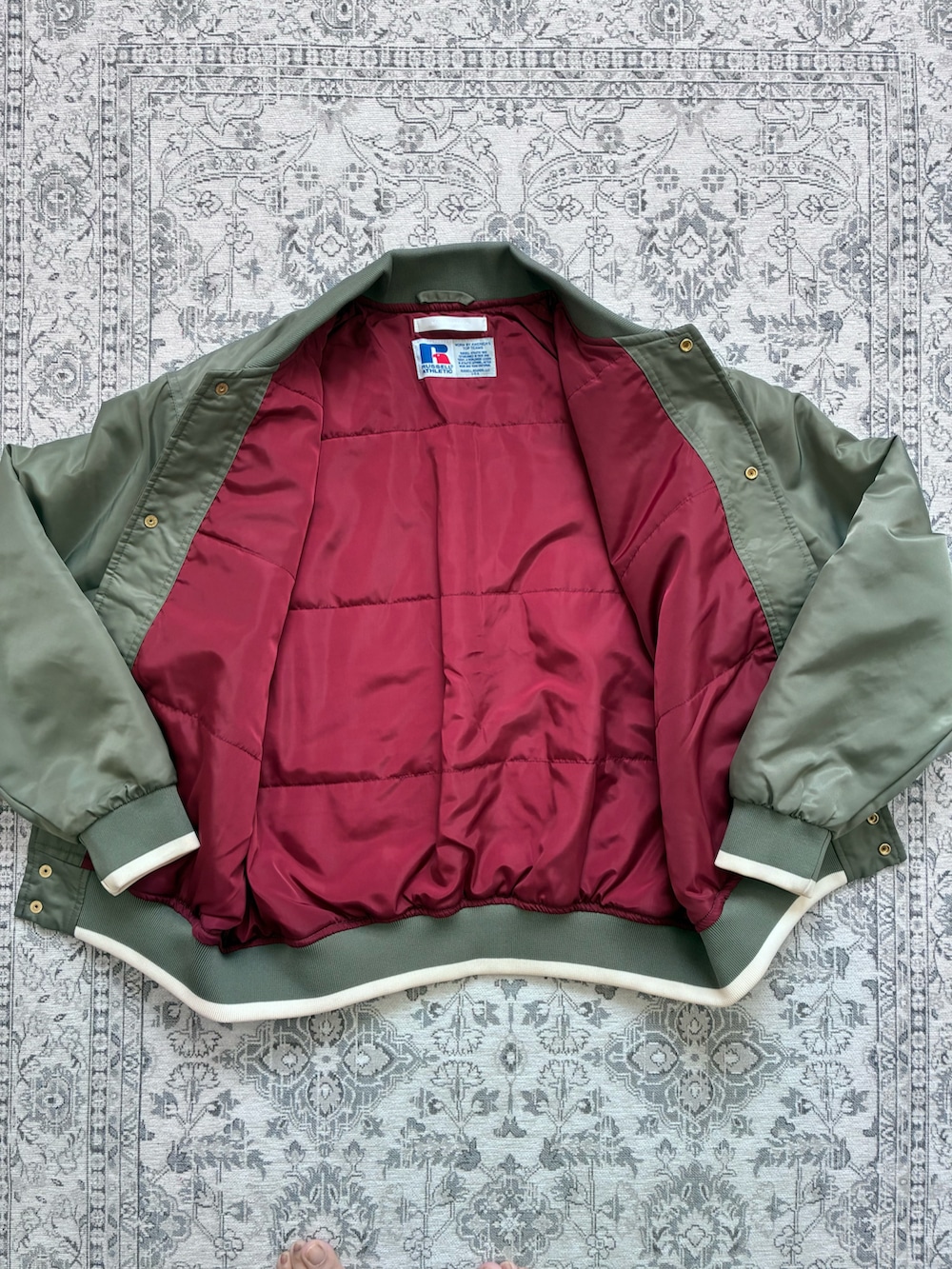 グリーン系のブルゾンを着用したレディースの冬コーディネートの2枚目の写真