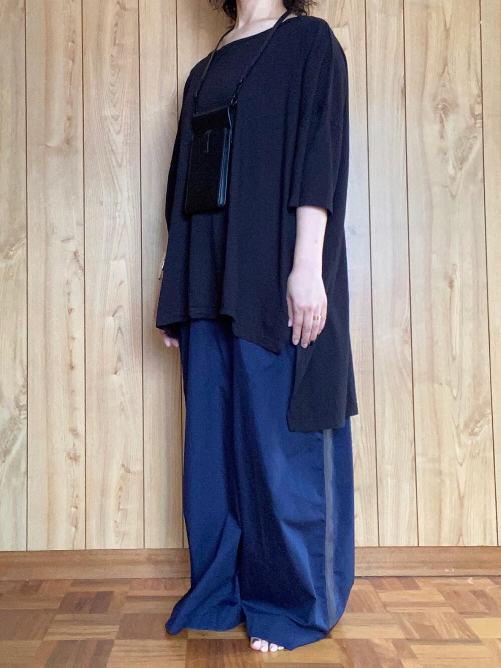 ブラック系のTシャツ/カットソー、ブルー系のパンツ、ブラック系の財布/小物を着用したレディースの夏コーディネートの3枚目の写真