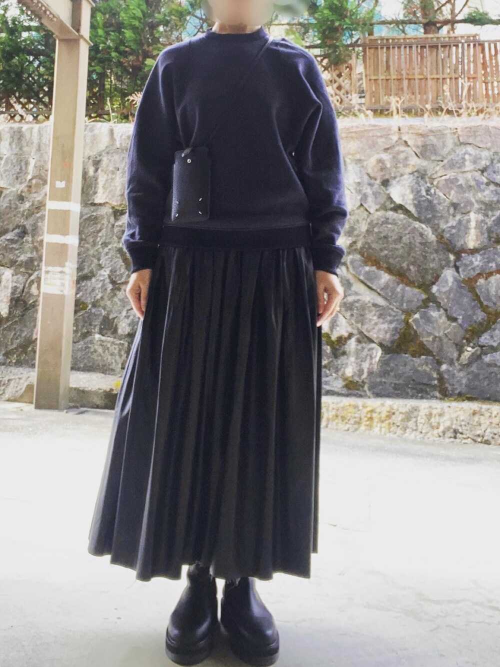 ブラック系のスウェット、ブラック系のスカート、ブラック系のブーツを着用したレディースの冬コーディネートの2枚目の写真