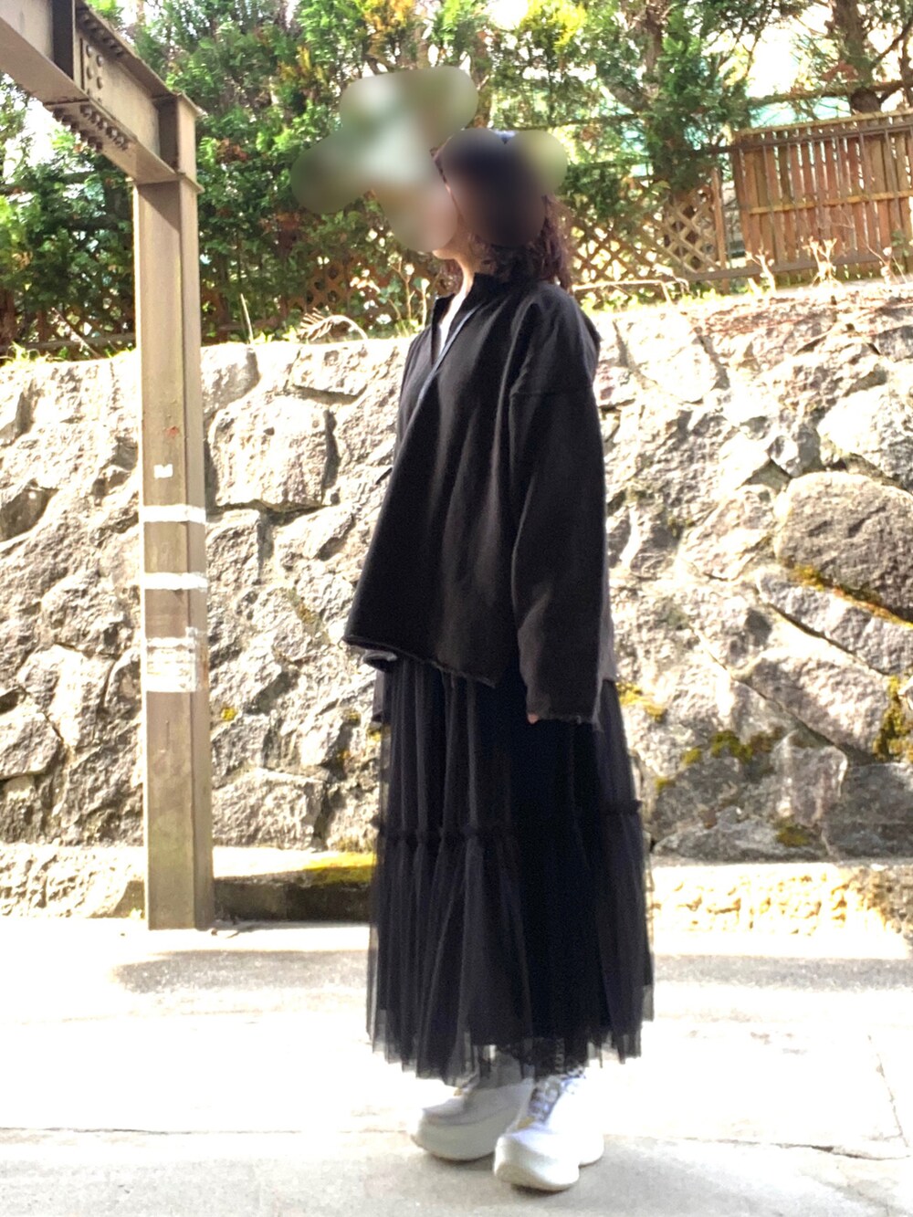 グレー系のスウェット、ブラック系のスカート、ホワイト系のシューズを着用したレディースの春コーディネートの2枚目の写真