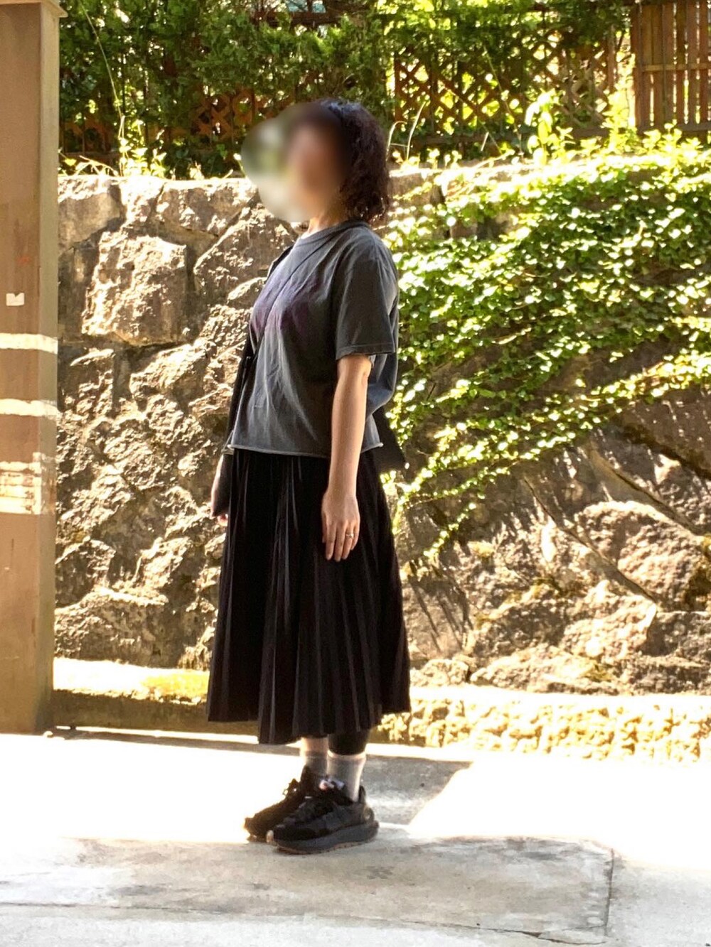 ブラック系のTシャツ/カットソー、ブラック系のバッグ、ブラック系のスカートを着用したレディースの夏コーディネートの2枚目の写真