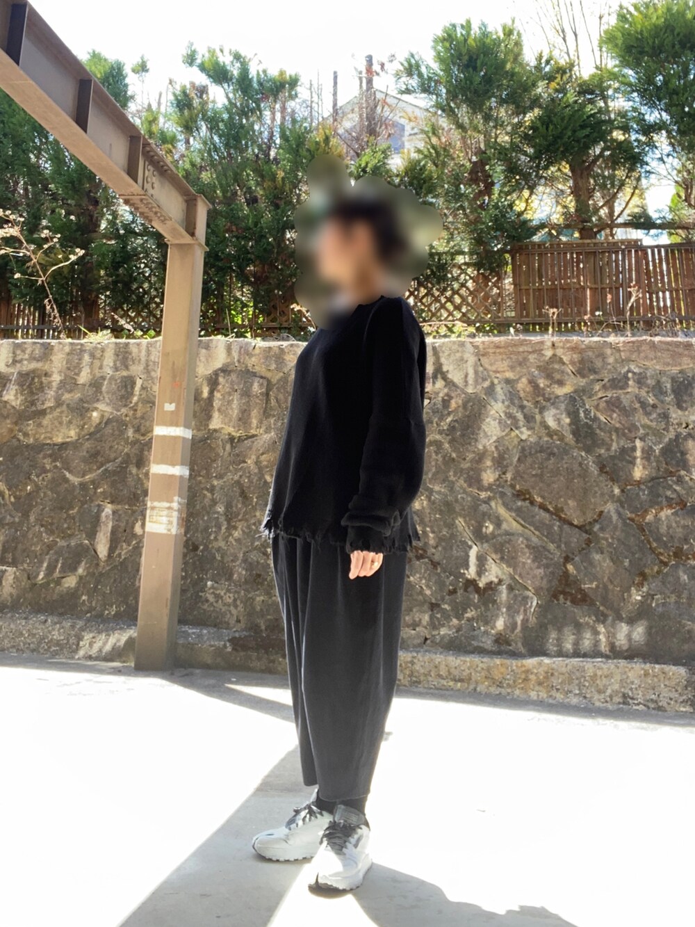 グレー系のTシャツ/カットソー、ブラック系のパンツ、ホワイト系のスニーカーを着用したレディースの春コーディネートの2枚目の写真