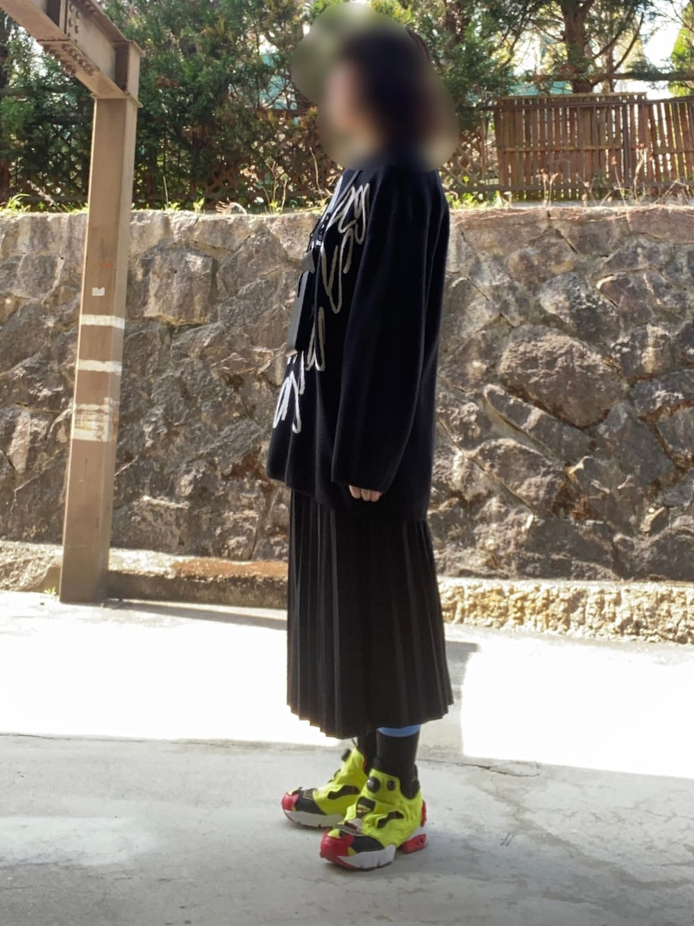 ブラック系のニット/セーター、ブラック系のスカート、その他のスニーカーを着用したレディースの春コーディネートの2枚目の写真