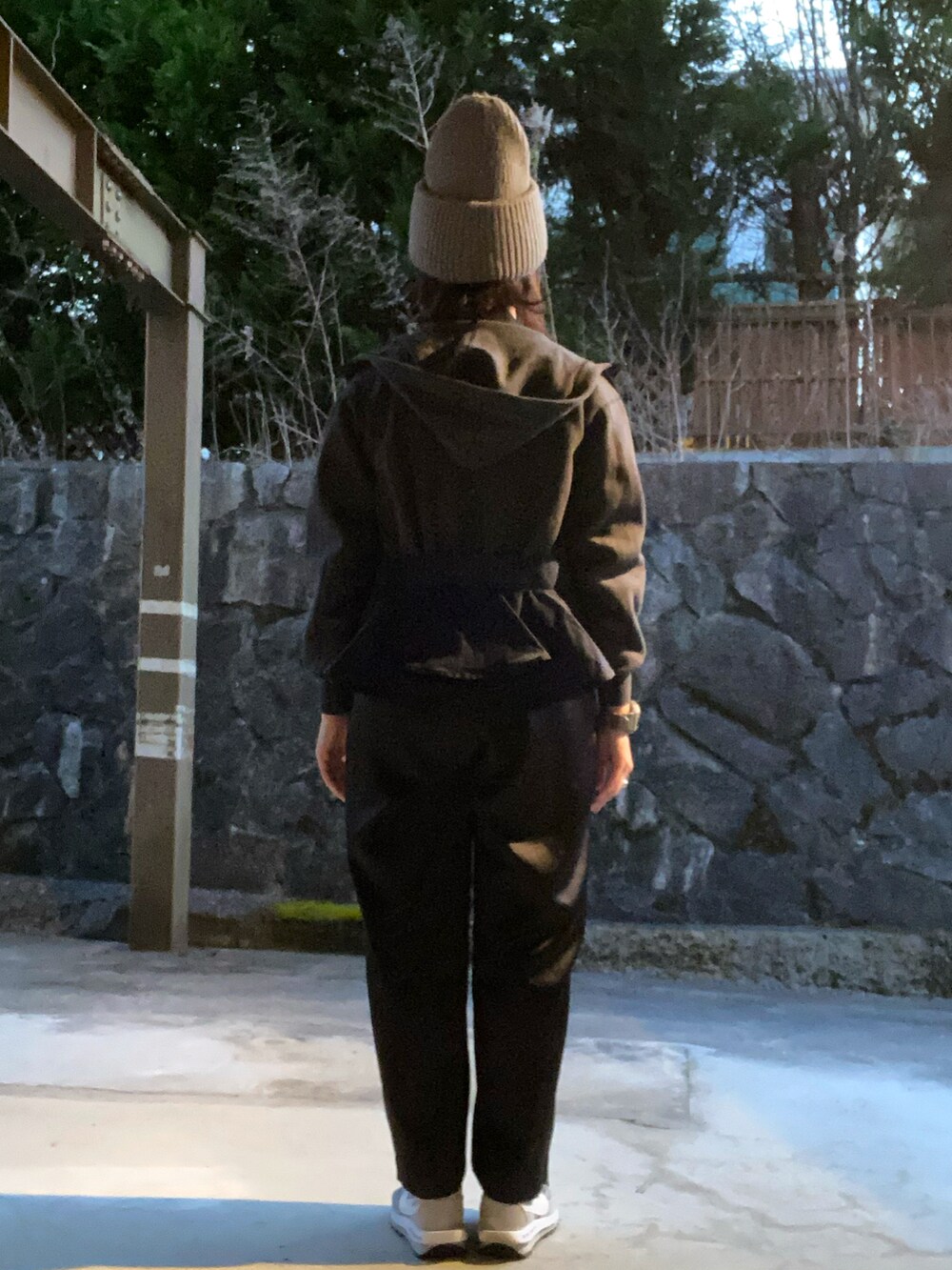 ブルー系のパーカー、ブラック系のショルダーバッグ、グレー系のスニーカーを着用したレディースの冬コーディネートの2枚目の写真