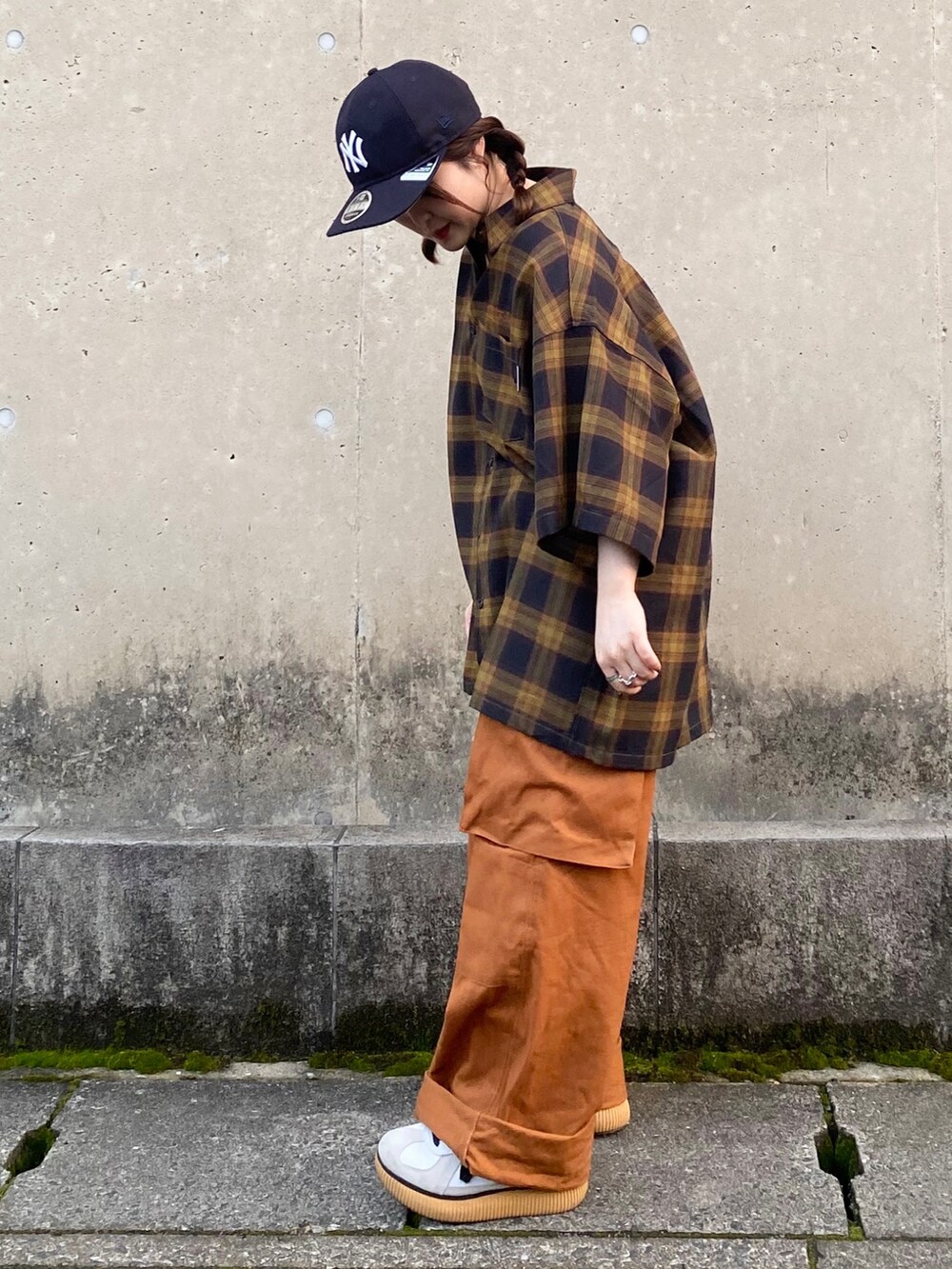 オレンジ系のカーゴパンツ、ホワイト系のスニーカー、ブラウン系のシャツ/ブラウスを着用したレディースの春コーディネートの2枚目の写真