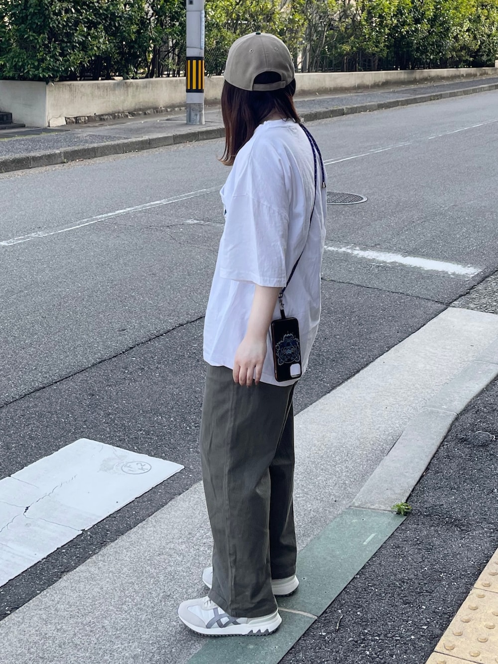 ホワイト系のTシャツ/カットソー、グリーン系のパンツ、ベージュ系のスニーカーを着用したレディースの夏コーディネートの2枚目の写真