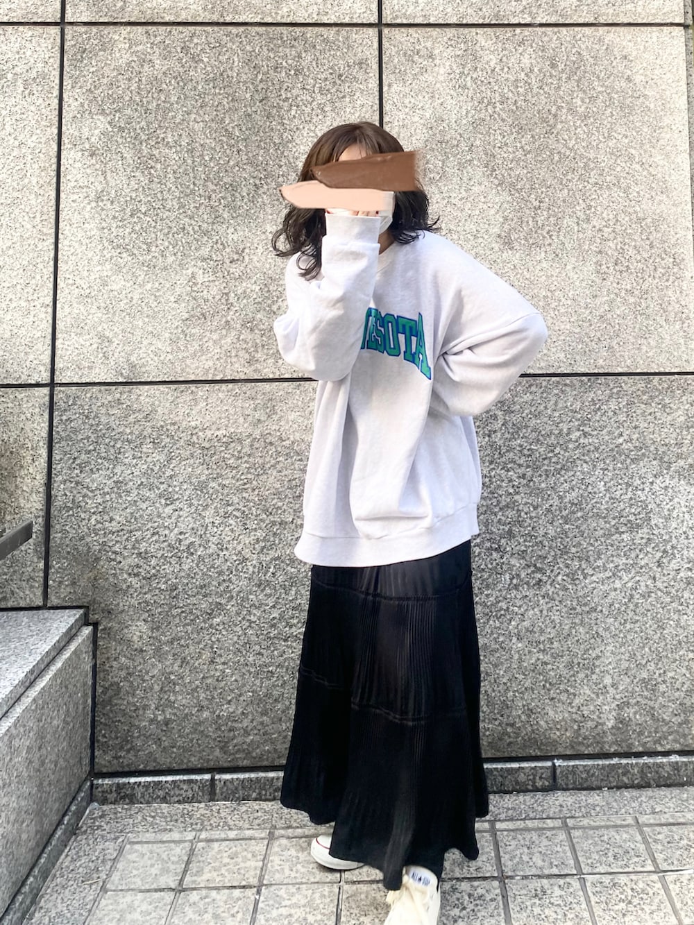 グレー系のスウェット、ブラック系のスカート、ホワイト系のスニーカーを着用したレディースの春コーディネートの5枚目の写真