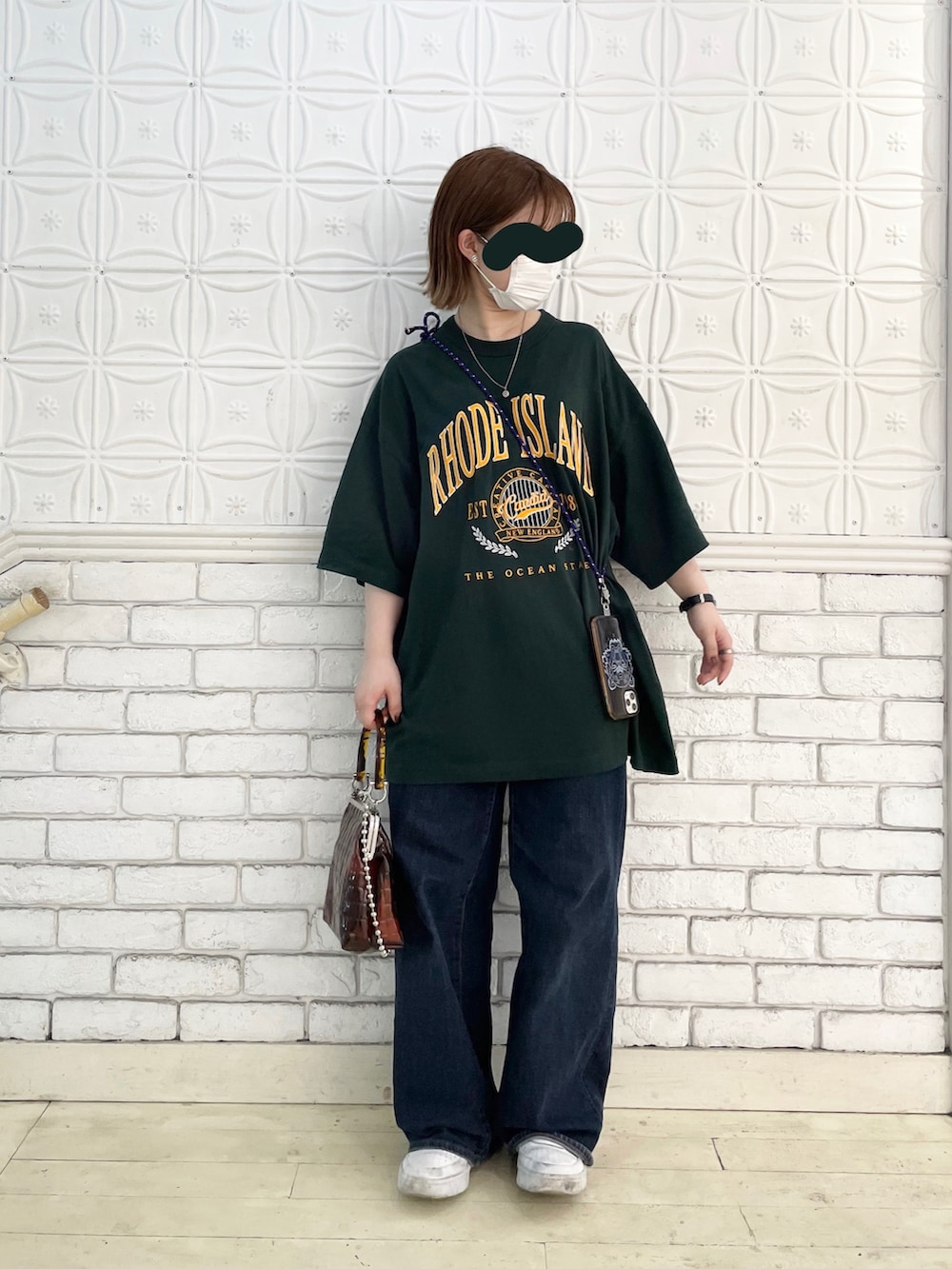 グリーン系のTシャツ/カットソー、ブラウン系のショルダーバッグ、ホワイト系のスニーカーを着用したレディースの夏コーディネートの2枚目の写真