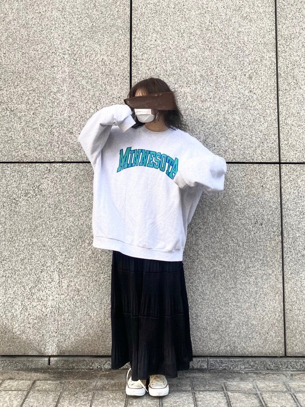 グレー系のスウェット、ブラック系のスカート、ホワイト系のスニーカーを着用したレディースの春コーディネートの3枚目の写真