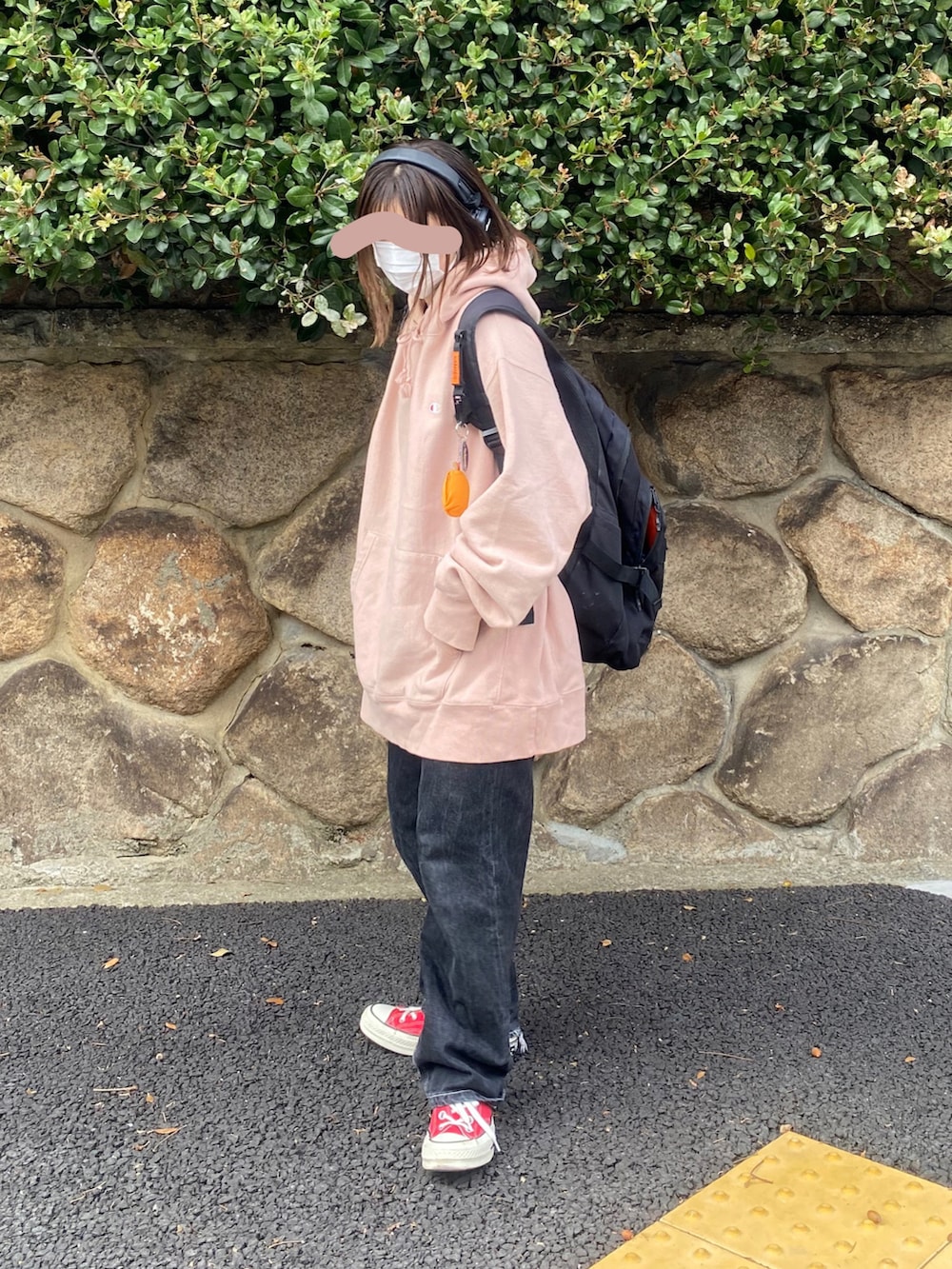 ブラック系のデニムパンツ、ブラック系のバックパック/リュック、ピンク系のパーカーを着用したレディースの秋コーディネートの2枚目の写真