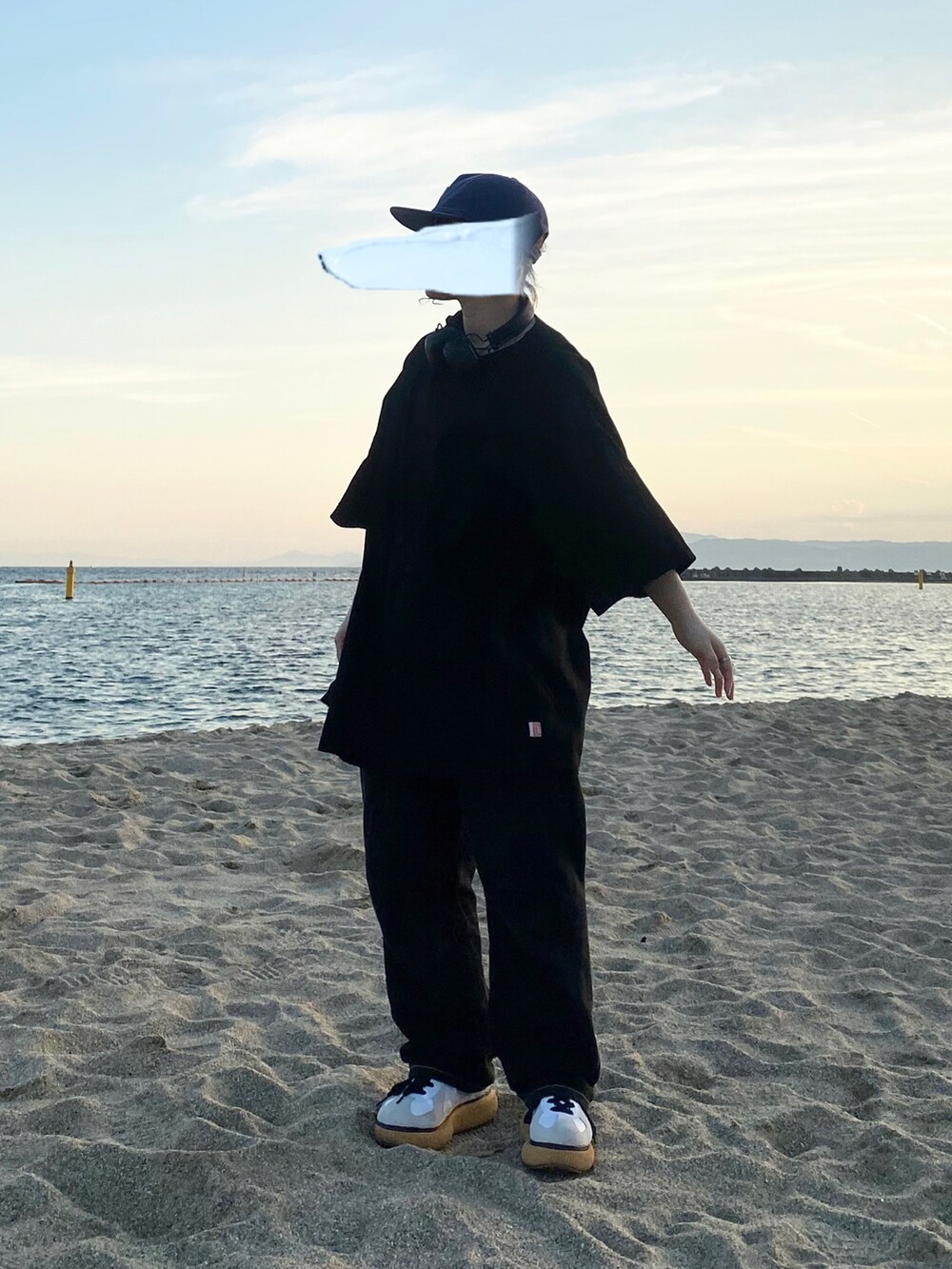 ブラック系のシャツ/ブラウス、ブラック系のデニムパンツ、ホワイト系のスニーカーを着用したレディースの秋コーディネートの2枚目の写真