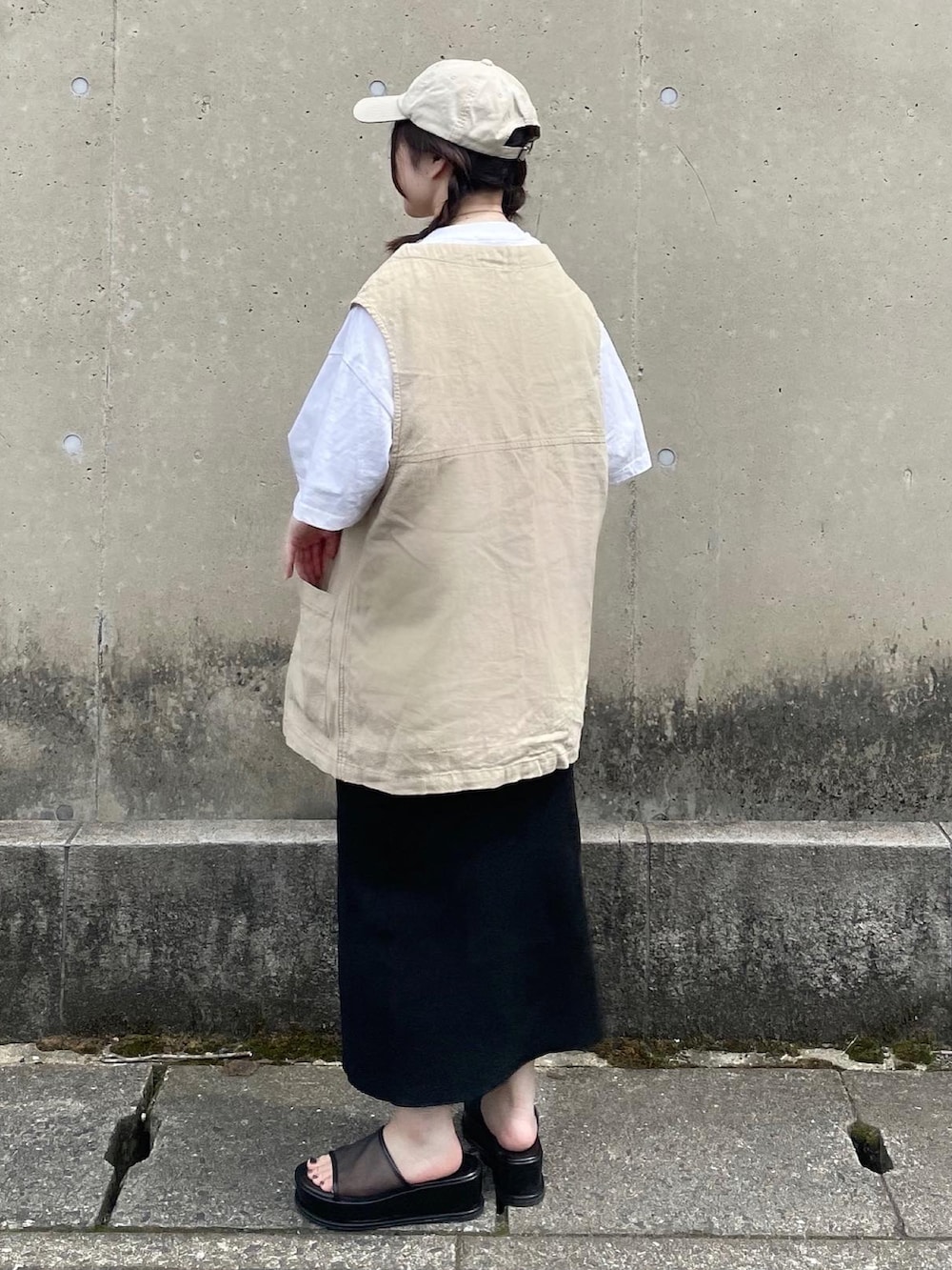 ベージュ系のベスト、ホワイト系のTシャツ/カットソー、ブラック系のスカートを着用したレディースの夏コーディネートの2枚目の写真