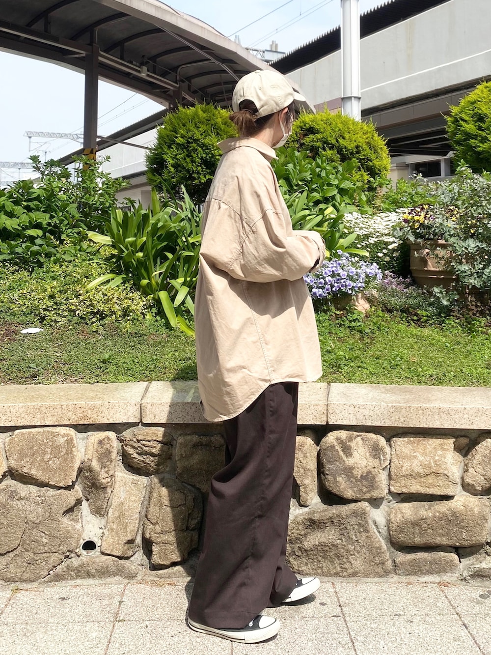 ブラウン系のその他パンツ、ブラック系のスニーカー、ベージュ系のキャップを着用したレディースの春コーディネートの2枚目の写真