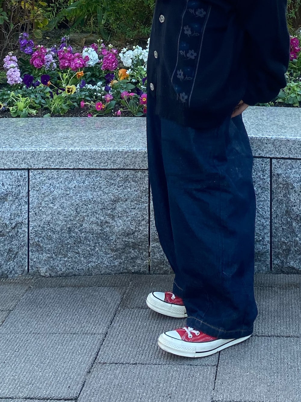 ブルー系のデニムパンツ、ブラック系のカーディガン/ボレロ、ホワイト系のニット/セーターを着用したレディースの秋コーディネートの2枚目の写真