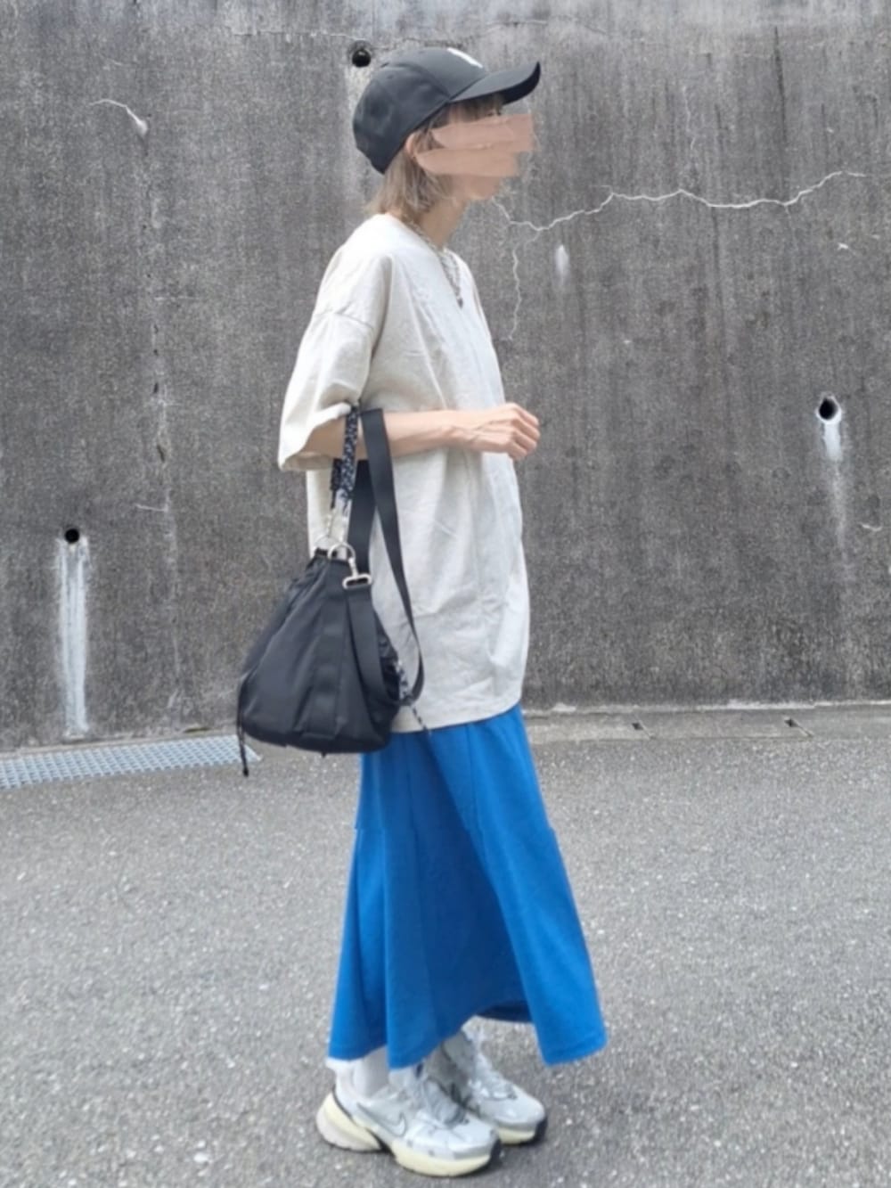 オレンジ系のTシャツ/カットソー、ブルー系のスカート、ホワイト系のスニーカーを着用したレディースの夏コーディネートの4枚目の写真