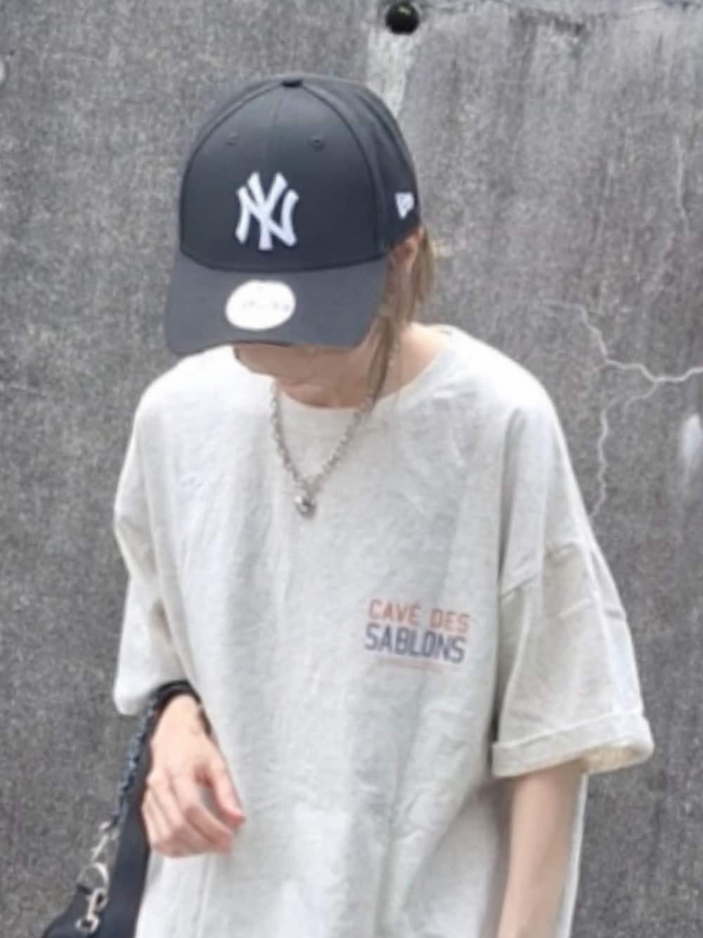 オレンジ系のTシャツ/カットソー、ブルー系のスカート、ホワイト系のスニーカーを着用したレディースの夏コーディネートの5枚目の写真