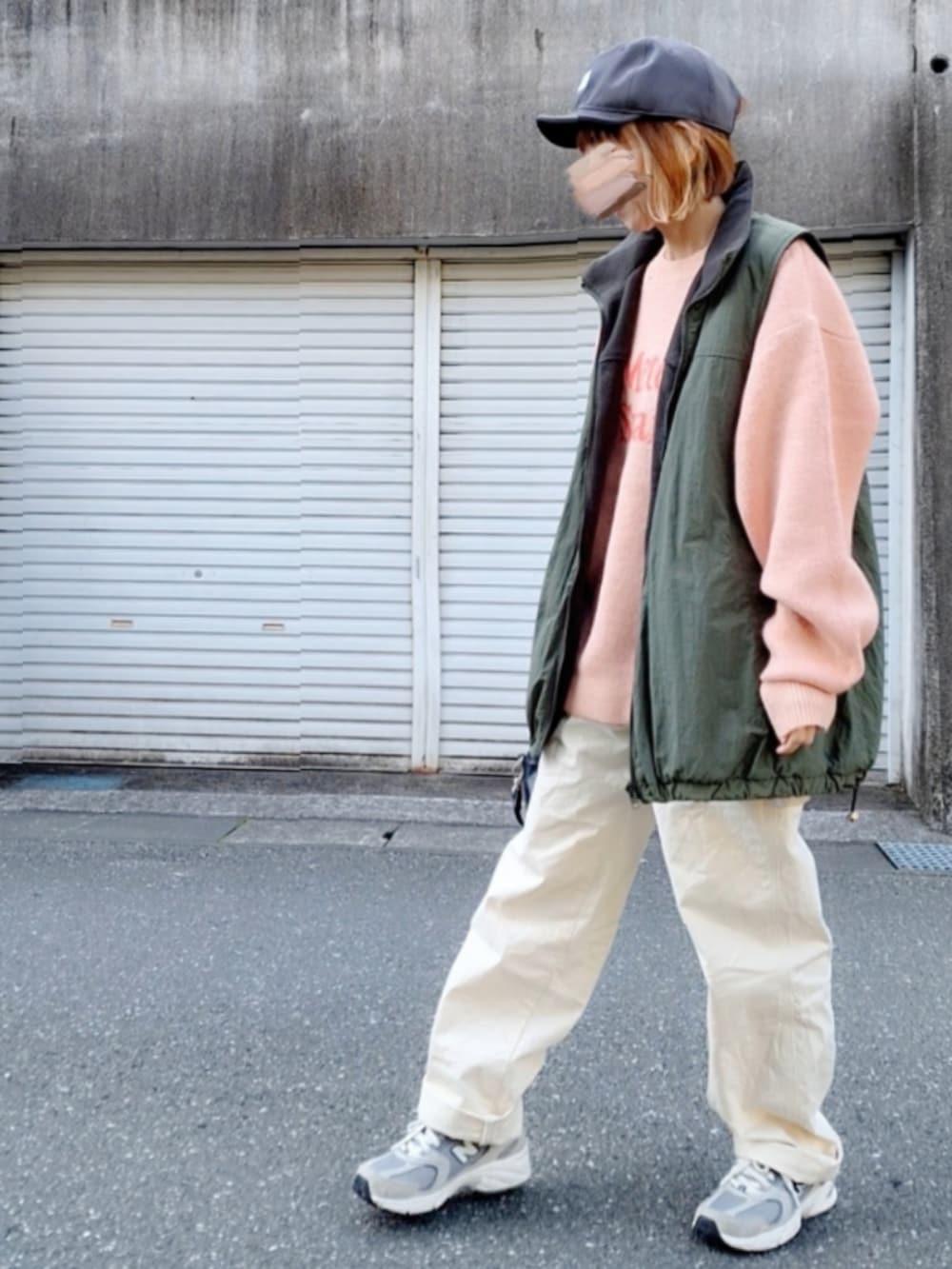 グレー系のスニーカー、ホワイト系のデニムパンツ、ブラック系のボストンバッグを着用したレディースの冬コーディネートの2枚目の写真