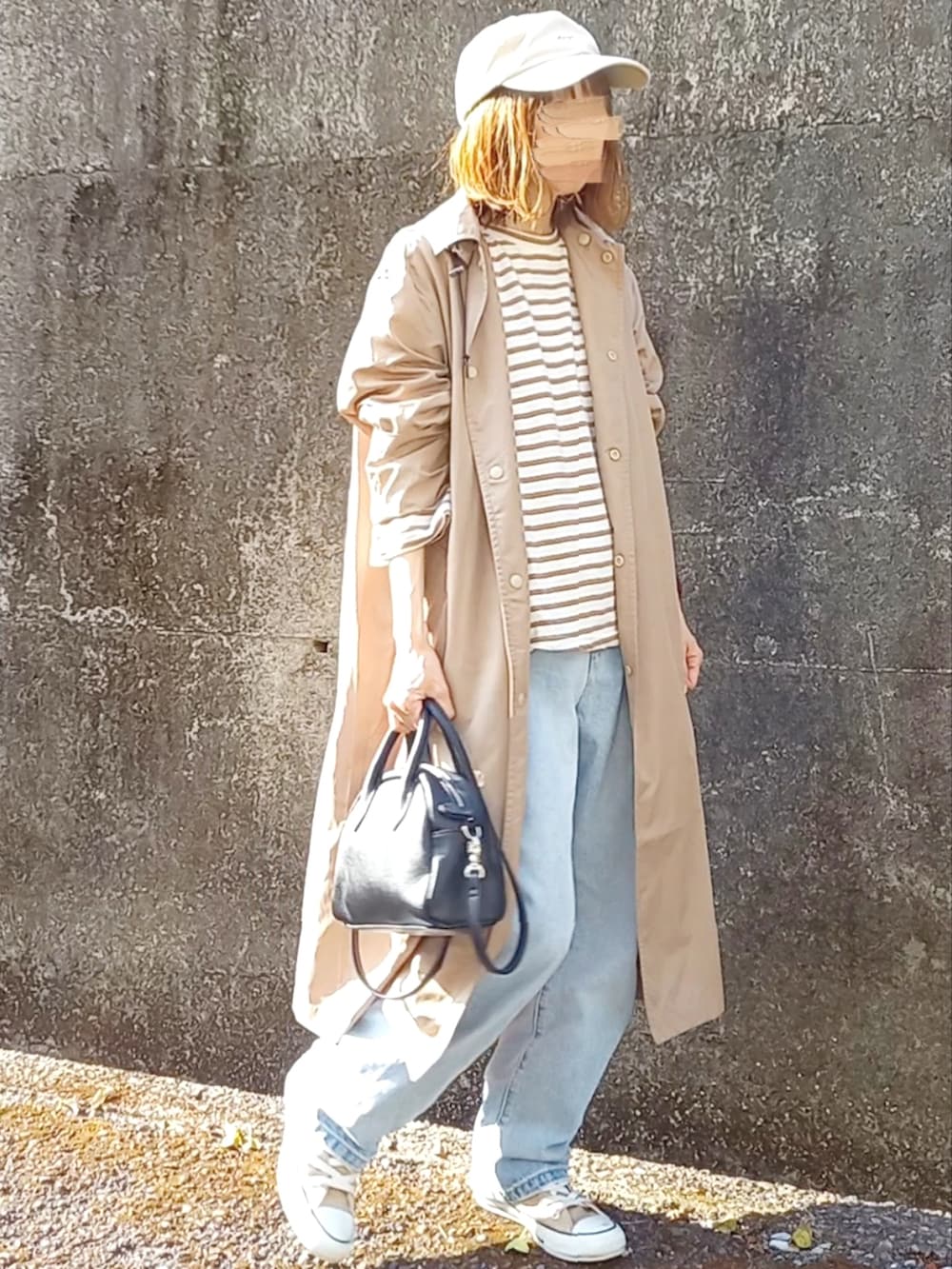 ブラウン系のTシャツ/カットソー、ブラック系のボストンバッグ、ブルー系のデニムパンツを着用したレディースの春コーディネートの2枚目の写真