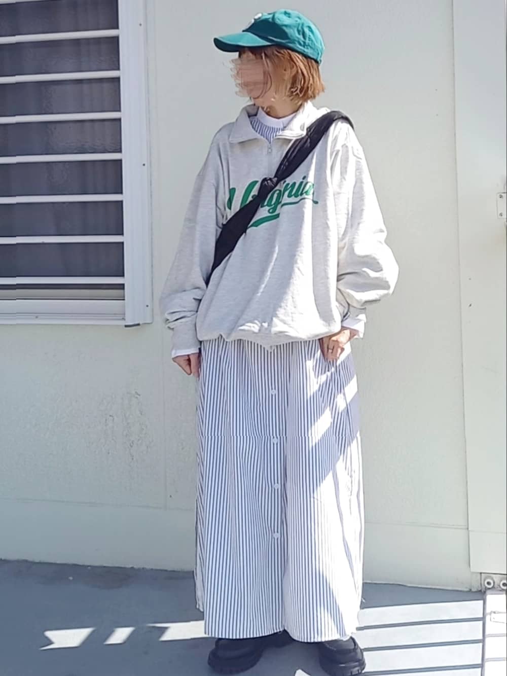 ホワイト系のワンピース、ブラック系のローファー、ブラック系のショルダーバッグを着用したレディースの春コーディネートの2枚目の写真