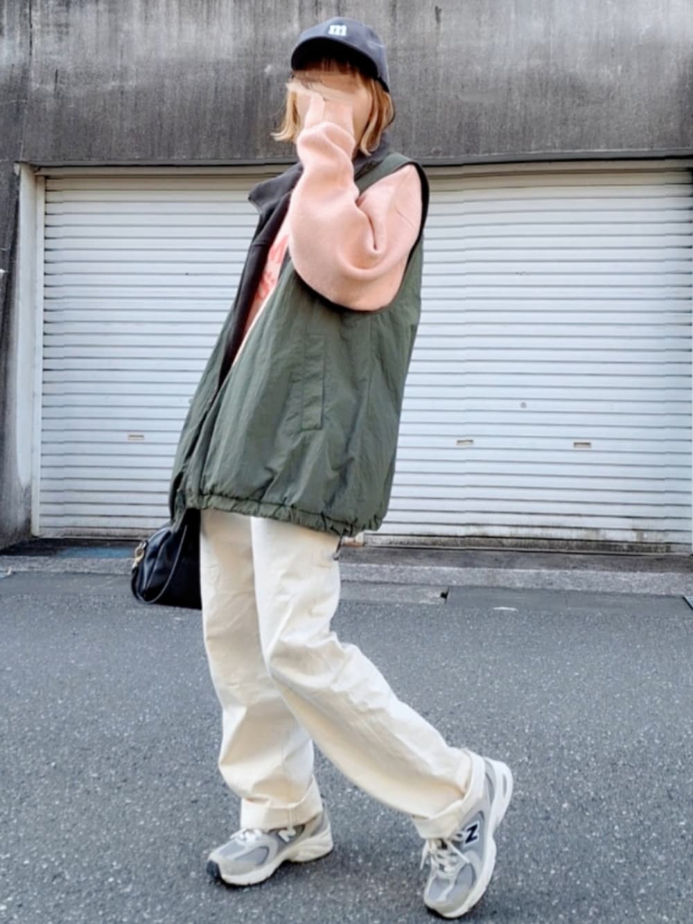 グレー系のスニーカー、ホワイト系のデニムパンツ、ブラック系のボストンバッグを着用したレディースの冬コーディネートの3枚目の写真