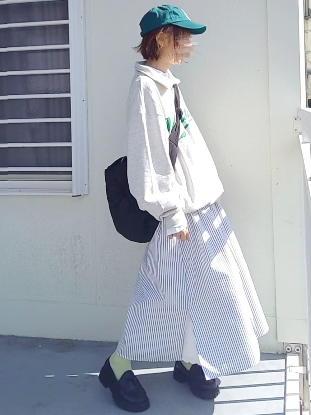 ホワイト系のワンピース、ブラック系のローファー、ブラック系のショルダーバッグを着用したレディースの春コーディネートの3枚目の写真