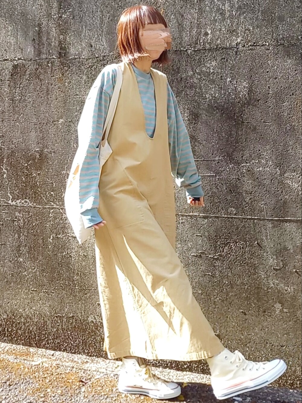 イエロー系のワンピース、グリーン系のTシャツ/カットソー、ベージュ系のトートバッグを着用したレディースの春コーディネートの2枚目の写真