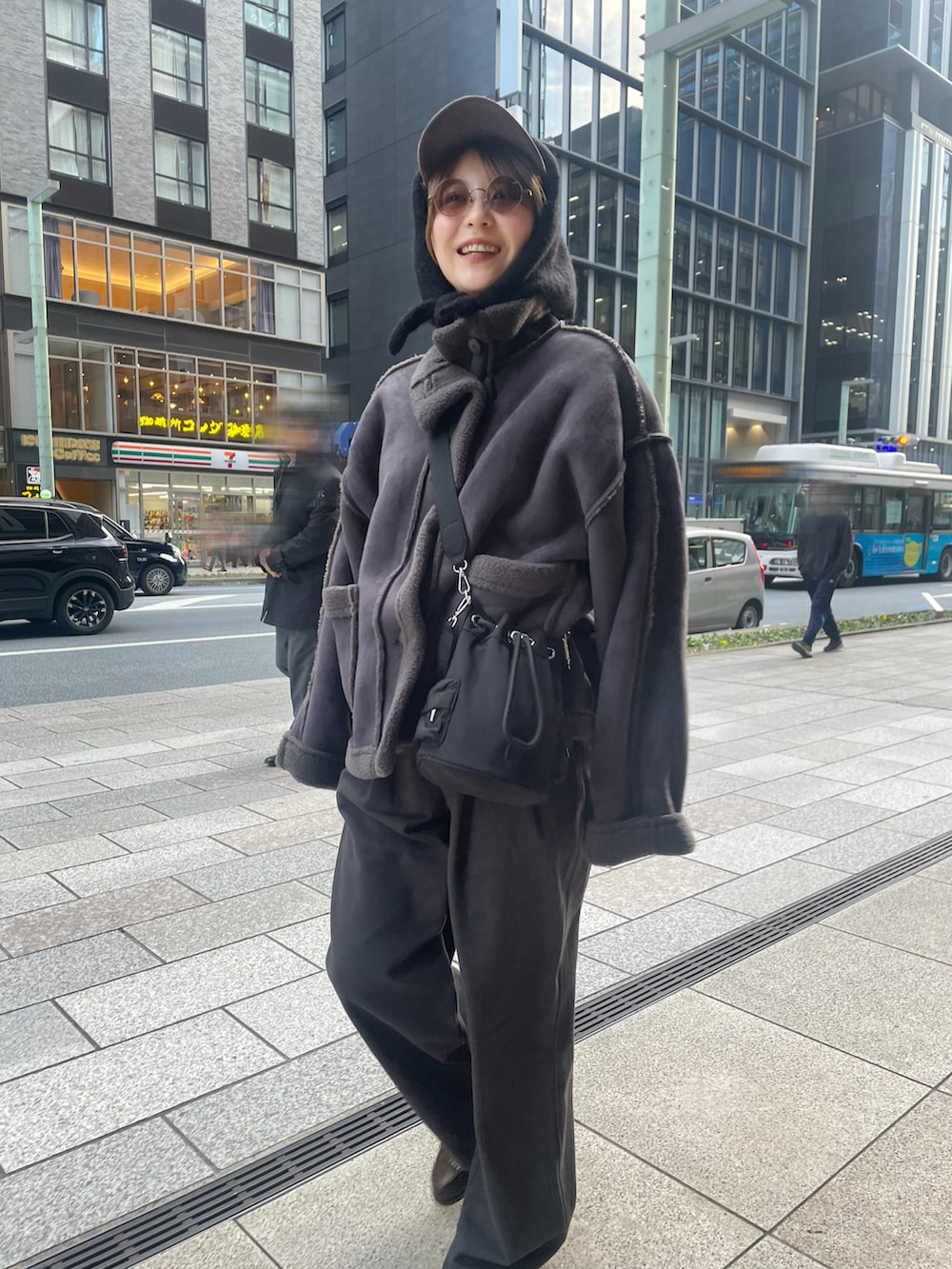 グレー系のその他パンツ、グレー系のムートンコート、ブラック系のマフラーを着用したレディースの冬コーディネートの2枚目の写真