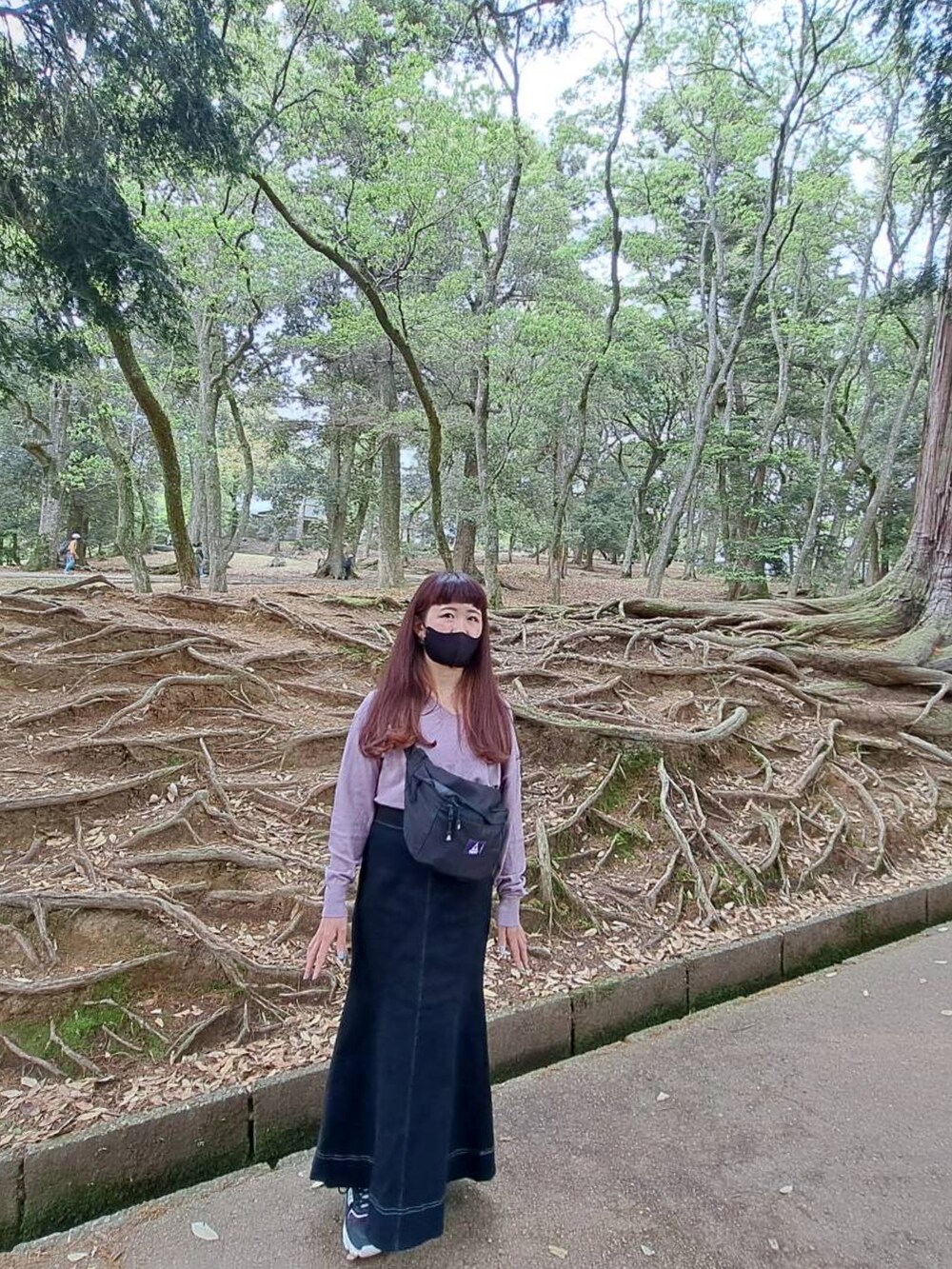 パープル系のニット/セーター、ブラック系のボディバッグ/ウエストポーチ、ブラック系のスカートを着用したレディースの春コーディネートの2枚目の写真