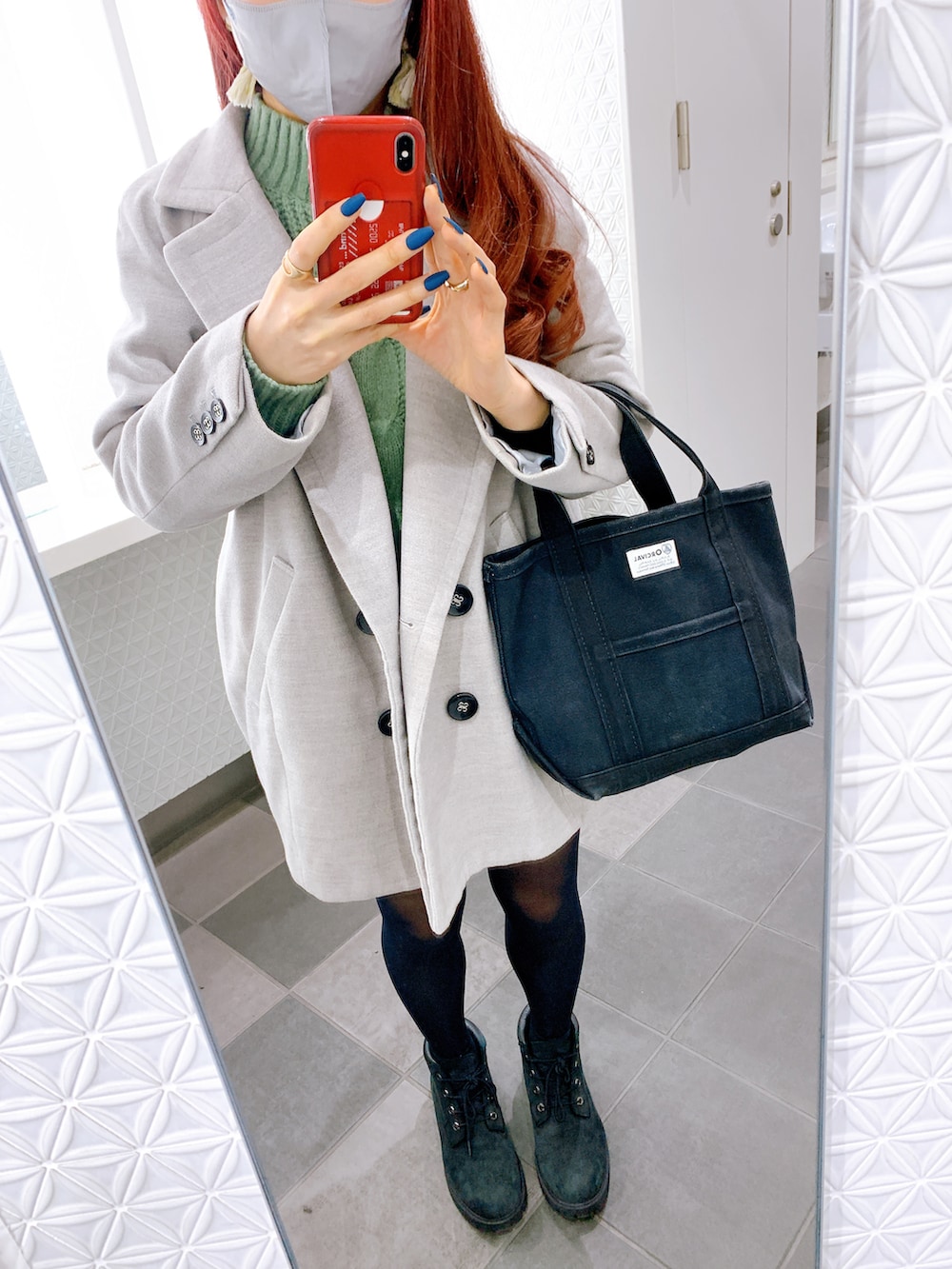 ブラック系のトートバッグ、ブラック系のブーツ、グリーン系のニット/セーターを着用したレディースの冬コーディネートの2枚目の写真