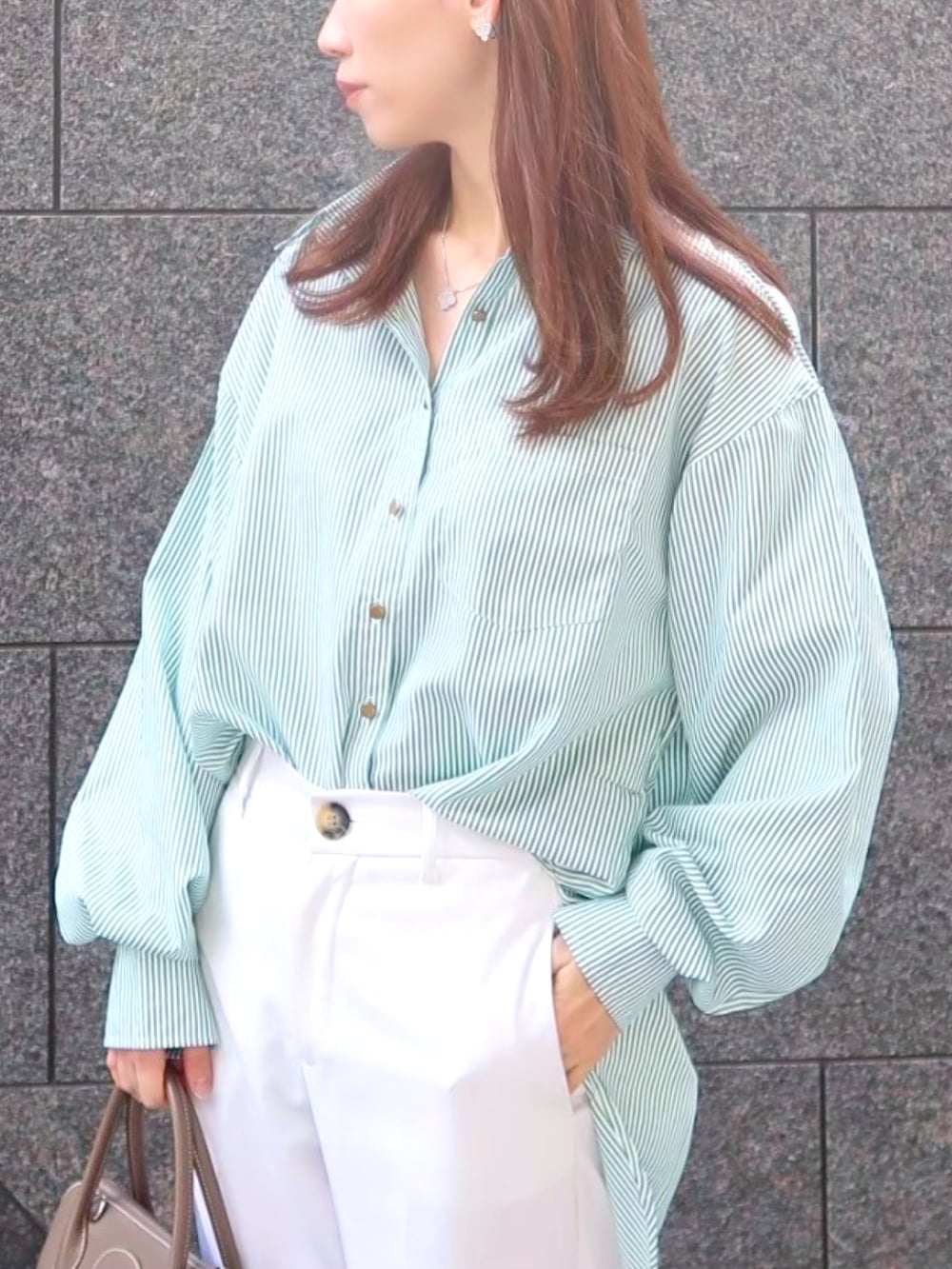 ホワイト系のパンツ、ホワイト系のスニーカー、ベージュ系のバッグを着用したレディースの春コーディネートの2枚目の写真