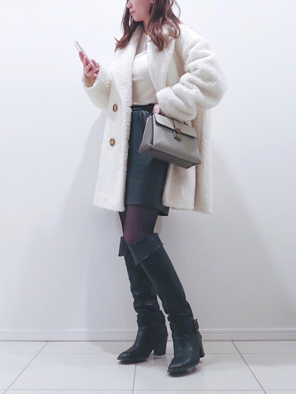 ホワイト系のジャケット/アウター、ホワイト系のニット/セーター、グレー系のショルダーバッグを着用したレディースの冬コーディネートの2枚目の写真