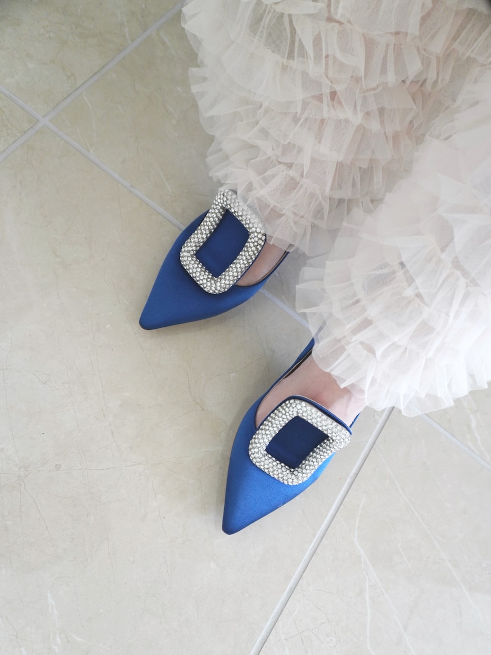 ホワイト系のスカート、ホワイト系のニット/セーター、ホワイト系のバッグを着用したレディースの春コーディネートの2枚目の写真