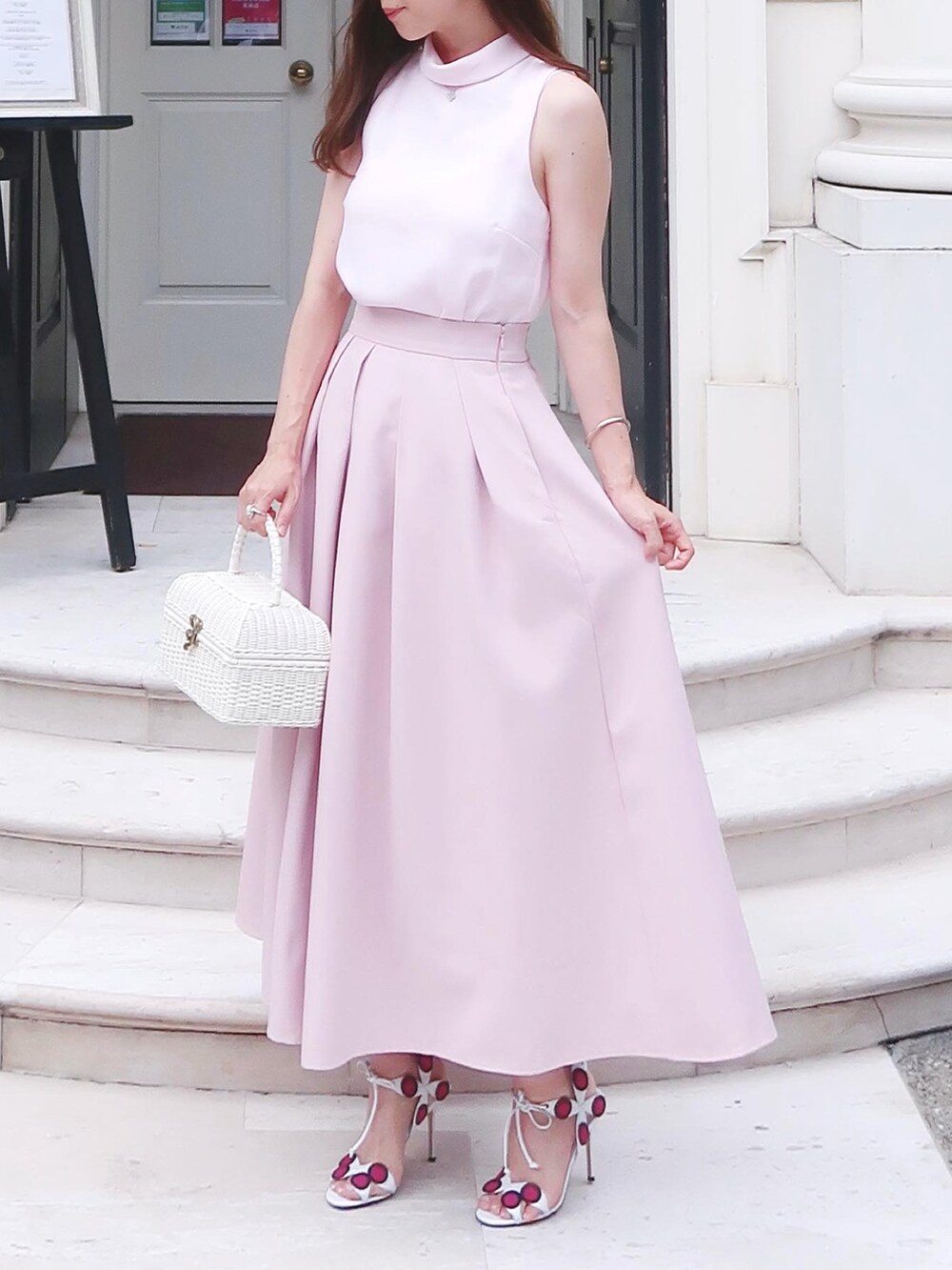 ピンク系のサンダル、ホワイト系のバッグ、ピンク系のスカートを着用したレディースの夏コーディネートの2枚目の写真