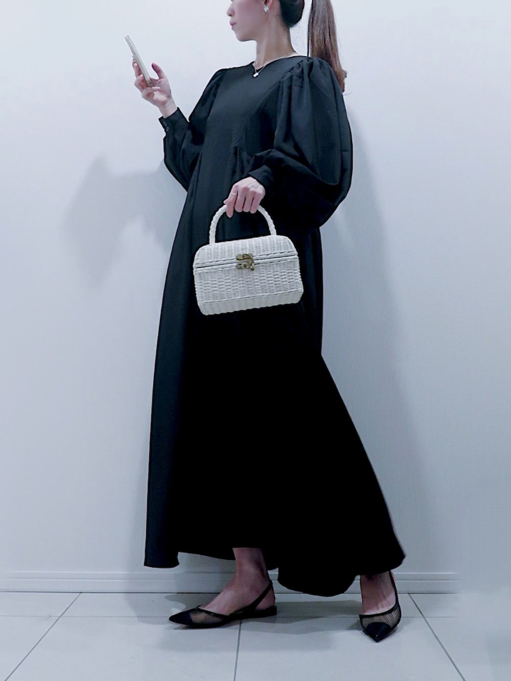 ホワイト系のバッグ、ホワイト系のその他アウター、ブラック系のシューズを着用したレディースの冬コーディネートの2枚目の写真