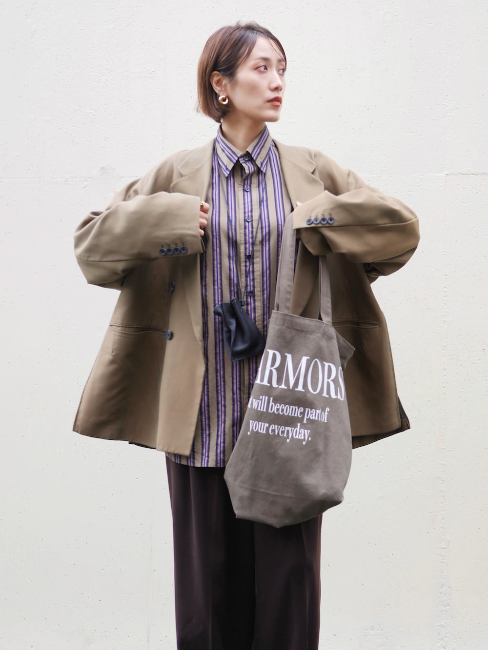 グリーン系のテーラードジャケット、ブラウン系のスラックス、ブラウン系のローファーを着用したレディースの秋コーディネートの4枚目の写真