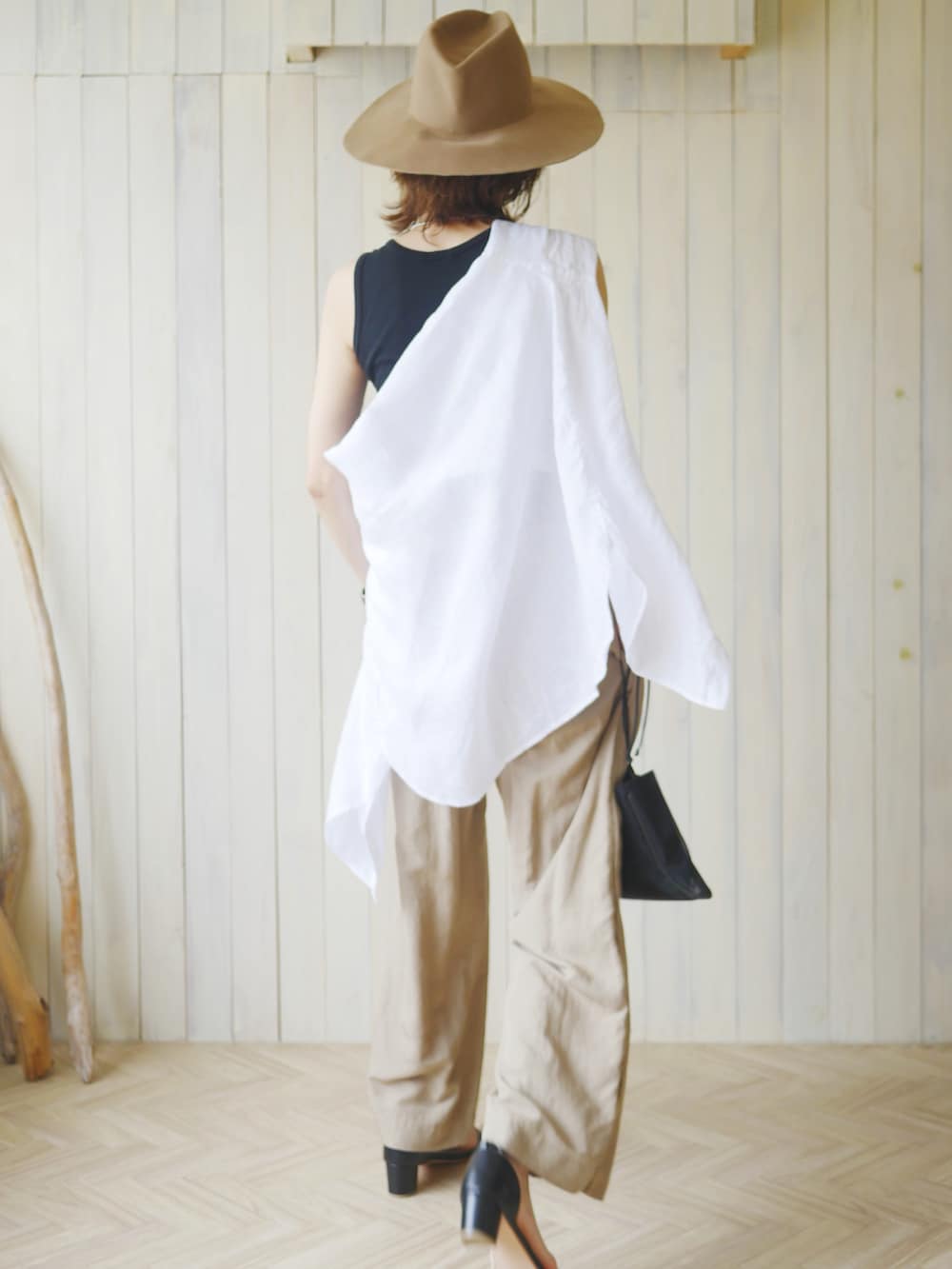 ホワイト系のシャツ/ブラウス、ブラック系のサンダル、ベージュ系のパンツを着用したレディースの夏コーディネートの2枚目の写真