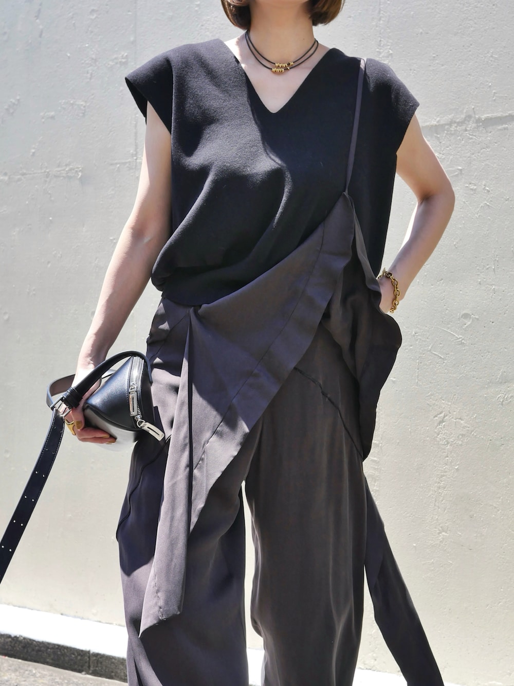 ブラウン系のその他パンツ、ブラック系のニット/セーター、ブラック系のショルダーバッグを着用したレディースの夏コーディネートの2枚目の写真