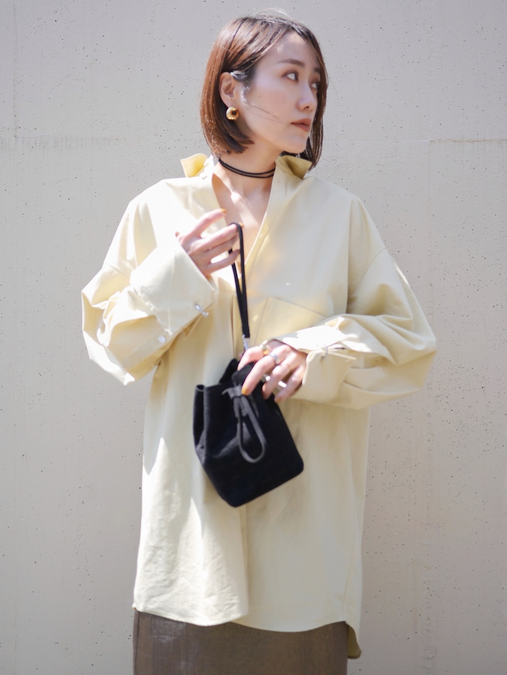 イエロー系のシャツ/ブラウス、ゴールド系のスカート、ブラック系のサンダルを着用したレディースの春コーディネートの4枚目の写真